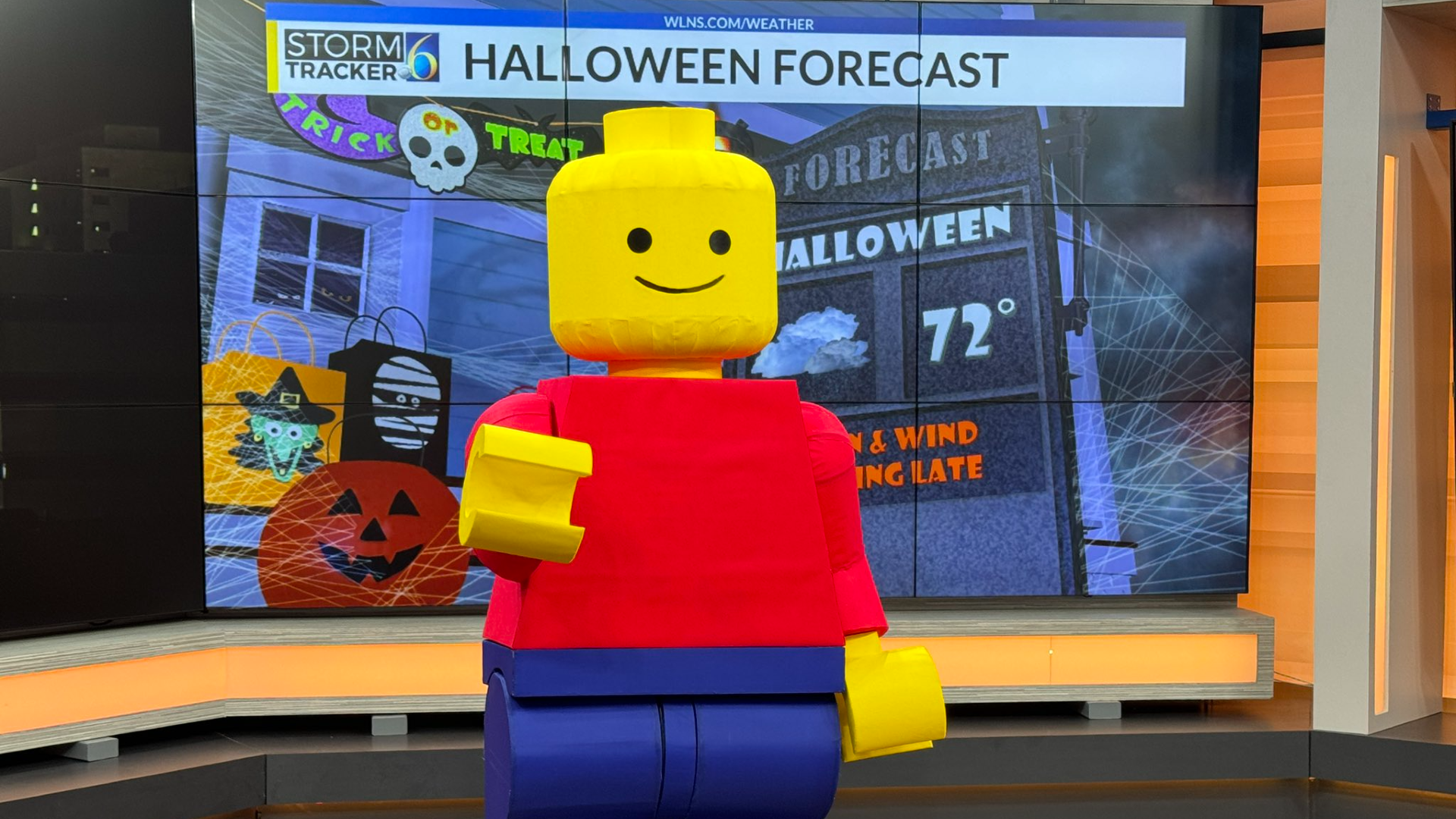 TV meteorologist presents weather in full LEGO minifigure costume